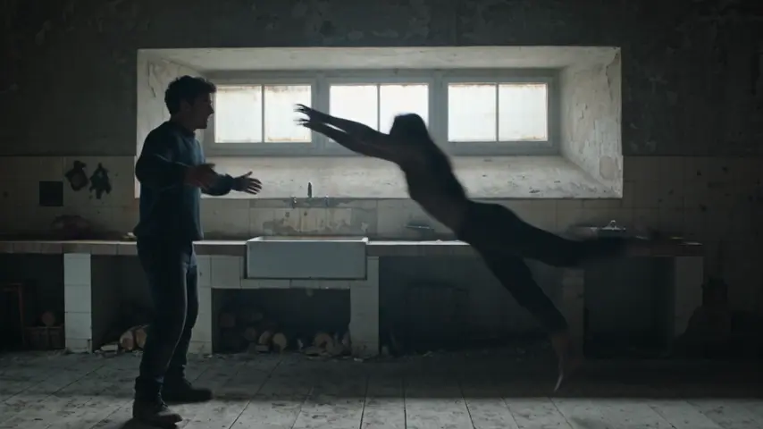 The zombie lunges toward the survivor with both arms extended